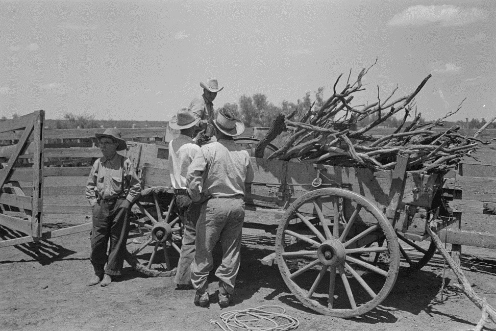 Cowboys gather around wagon in 1939