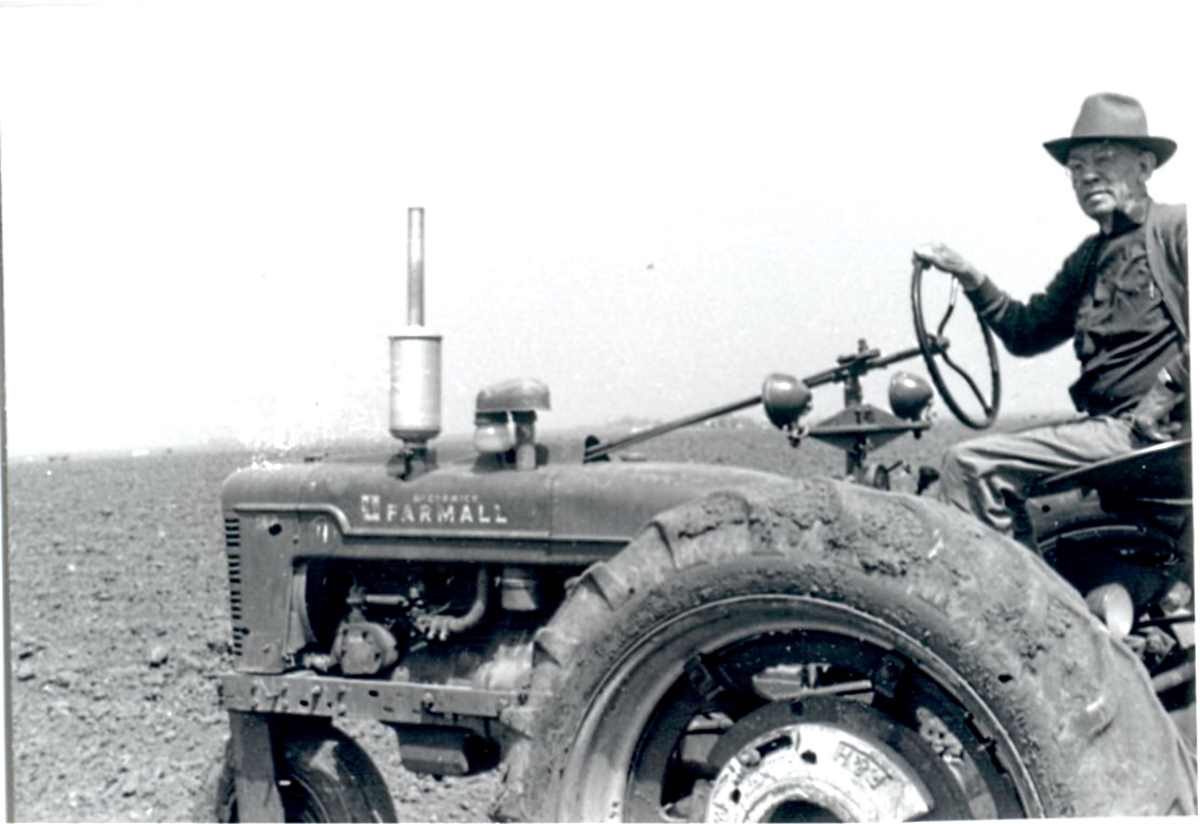 Joe Phillips on His Farmall Tractor in 1950s