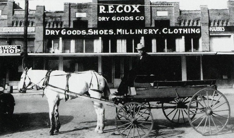 Photo from 1930 depicts drayman named "Ross" with his wagon and horse in front the R.E. Cox Dry Goods company in Stephenville Texas.