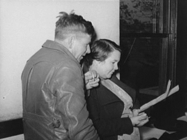 Farmer and wife studying FSA farm and home plan in 1939